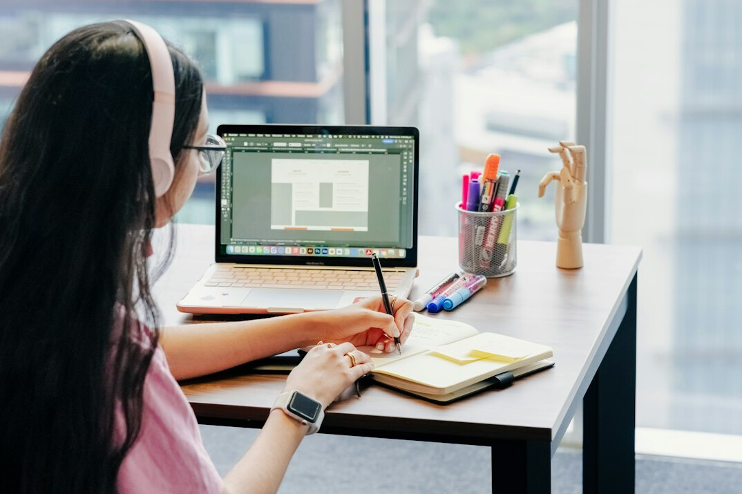 person writing code at desk